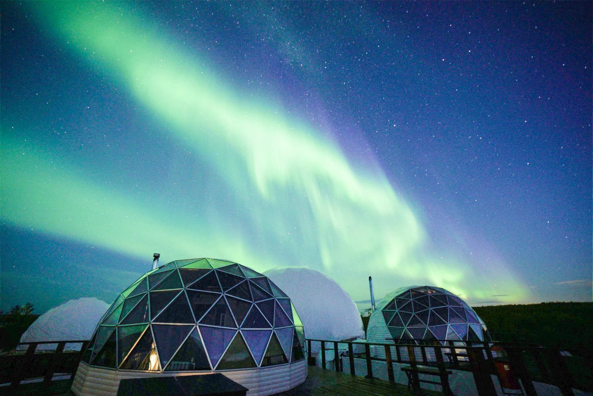Северное сияние над купольными домиками Aurora Village в Мурманской области